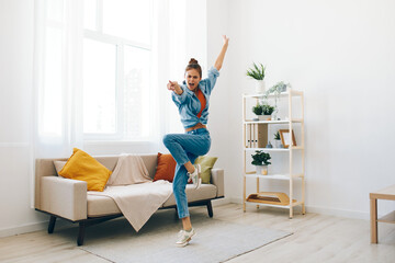 Joyful Woman Jumping with Music in a Playful Indoor Home Concept