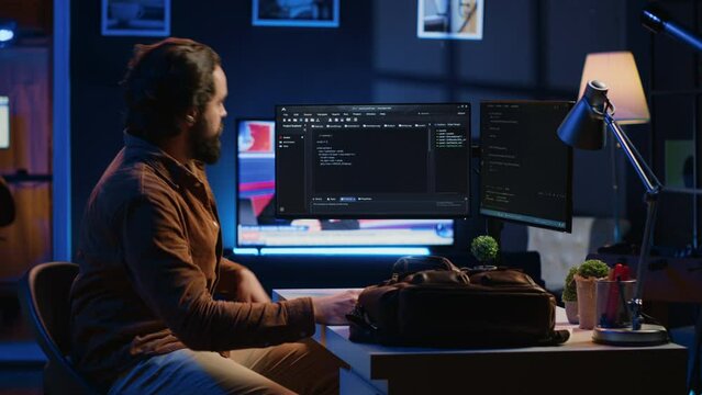 Freelancing software programmer arriving in personal office at home, resuming work on coding. Self employed IT specialist starting job shift in apartment, writing lines of code on computer, camera A