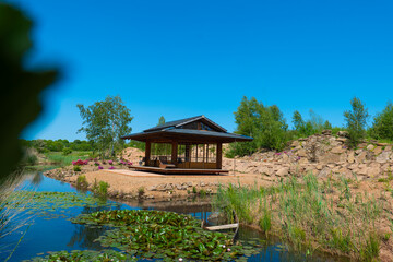 Japanese tea house near a pond with water lilies and willows.Tea pavilion Japanese style gazebo.Tea...