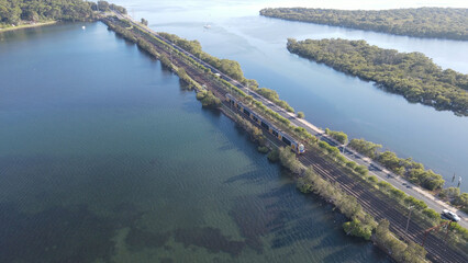 Aerial drone view of a train travelling over the rail bridge at Woy Woy on the Central Coast of New...