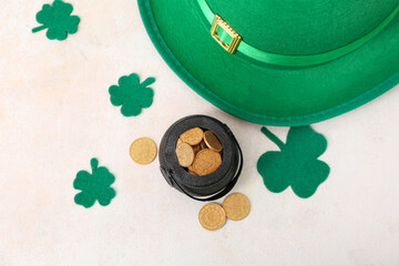 Pot with golden coins, leprechaun hat and clovers on light background. St. Patrick's Day celebration