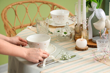 Female hands with beautiful table setting for International Women's Day celebration, closeup