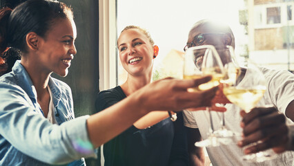 Three diverse best friends toast in white wine while laughing at each other