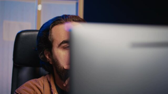 Software technician puzzled in front of computer screen while writing complex code, thinking of solution. IT expert feeling confused while trying to solve database bugs, camera B close up