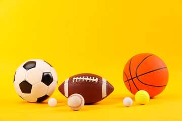 Many different sports balls on yellow background, space for text