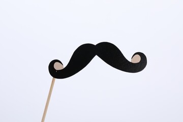 Fake paper mustache on stick against white background