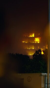 Two unrecognizable men witness a fire