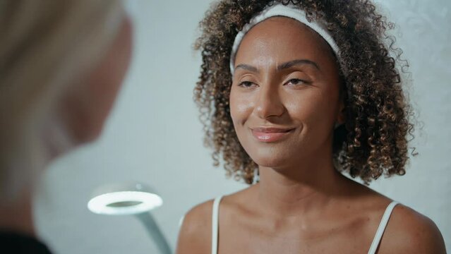 Doctor hands making marks on face closeup. African american visiting beauty spa