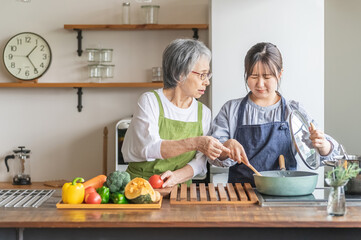 料理を見て文句を言う高齢者女性と泣く若い女性（嫁いびり）
