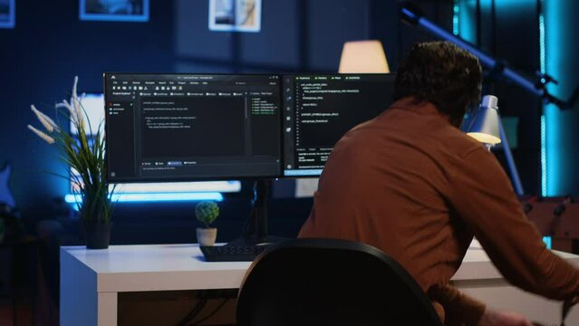 Remote software developer arriving in personal office at home, starting job shift with cup of coffee. Teleworker enjoying hot beverage while writing lines of code on computer, camera A