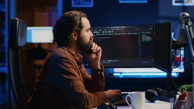 Programmer doing web development during remote job shift in neon lit home office, finishing coding project. IT specialist sitting at computer desk, working on desktop PC, camera A