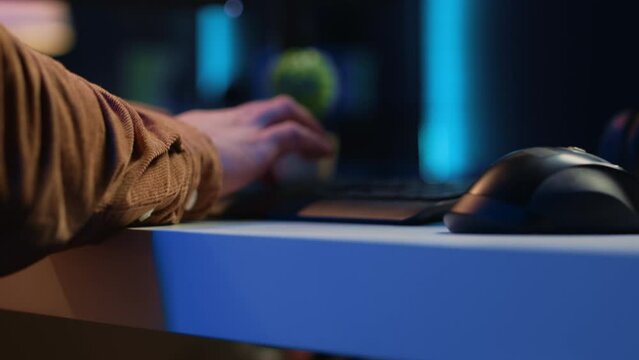 Focus on computer peripherals used by programmer to write lines of code on PC screen. Close up shot of keyboard and mouse used by developer working on fixing database errors, camera A