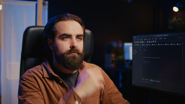 Developer overthinking solutions while doing programming during remote job shift in home office while drinking coffee. IT admin enjoying hot beverage working on PC early in the morning, camera B