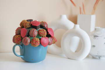 A teacup filled with chocolate covered strawberries and heartshaped treats