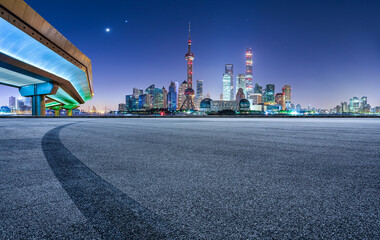 Asphalt road square and pedestrian bridge with modern city buildings scenery at night in Shanghai