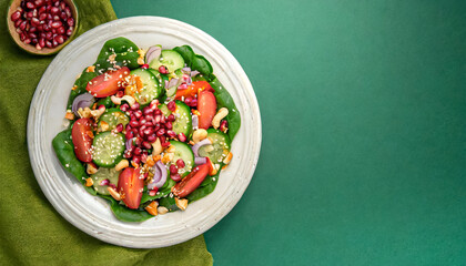 spinach salad, healthy salad. top view of spinach salad with tomato, onion, sesame seeds and cashew, copy space, healthy eating