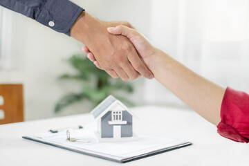 Businessmen and brokers real estate agents shake hands after completing negotiations to buy house insurance and sign contracts. Home insurance concept