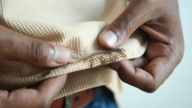  men holding dirty shirt, showing making stain