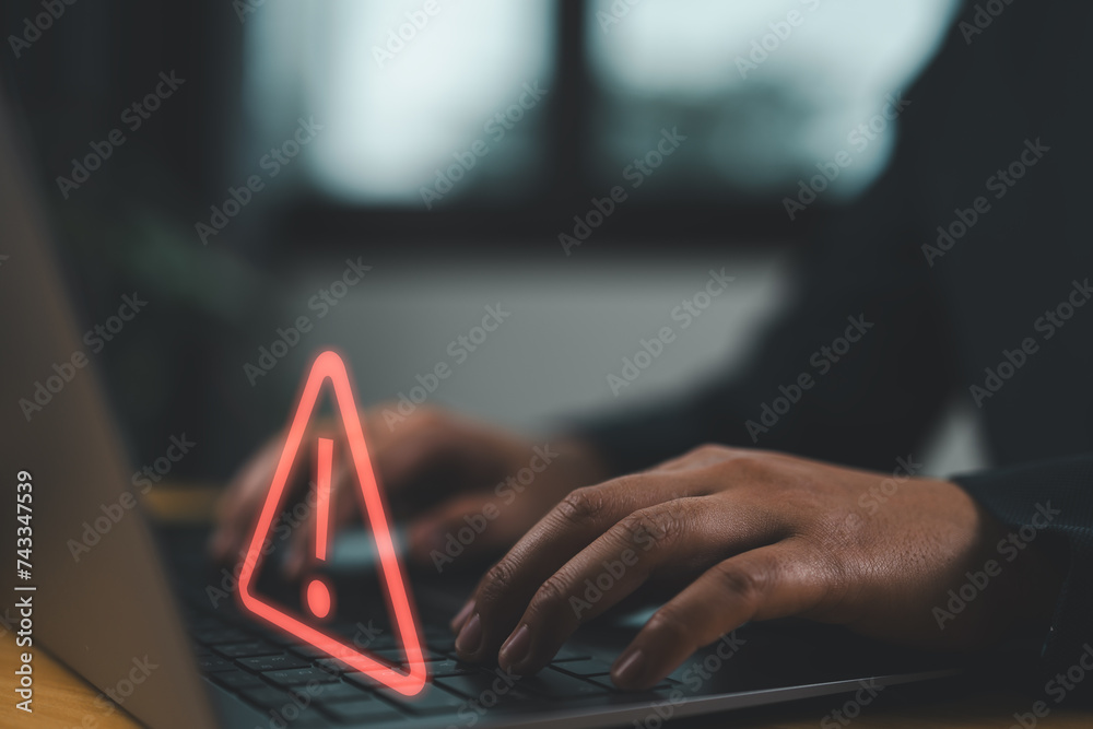 Poster Businessman using computer laptop with triangle caution warning sing for notification error and maintenance concept..