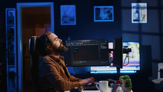 Software engineer doing programming using augmented reality visualization during remote job shift in home office. IT admin working on computer, looking at AR hologram, camera A