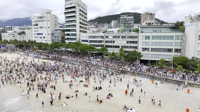 Aerial shot drone flies backwards from parade along boardwalk in Ipanema for Iemanj&aacute; Day