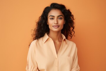 Portrait of beautiful young asian woman with curly hair on orange background