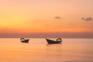 Naklejka premium Traditional fishermen boat at the coast of Havelock island in Andaman islands archipelago during colorful sunset