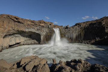 Scenic Aldeyjarfoss waterfall and basalt columns in the north of Iceland on a bright sunny day