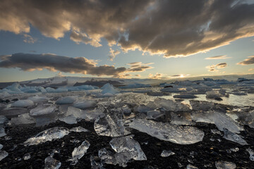 Ice chunks washed ashore at the edge of Jokulsarlon glacier lagoon at sunset