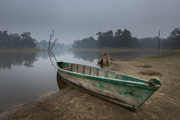 Old boat at the shore of a lake in Chitwan National Park buffer zone called 'Twenty thousand...