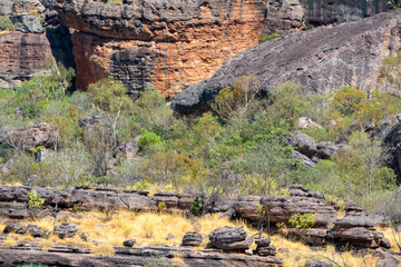 Rugged scenery in Outback Australia, with red dust plains, dramatic rock formations, and vast, open...