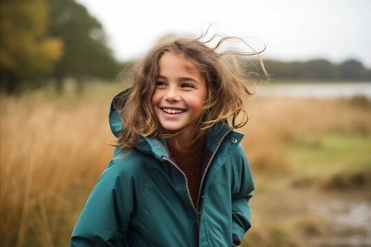 Portrait of a smiling little girl in autumnal clothes outdoors.