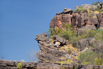 Rugged scenery in Outback Australia, with red dust plains, dramatic rock formations, and vast, open...