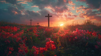 Fotobehang The sun rises, casting a warm glow behind a solitary cross on a dew-covered hill with flowers field, symbolizing hope and resurrection. © feeling lucky