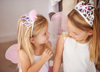 Girl, sister and play with fairy costume in bedroom of home for dress up, fantasy fun or tiara with smile. Family, children and face with princess outfit for bonding, fashion or happy with wings © MV/peopleimages.com