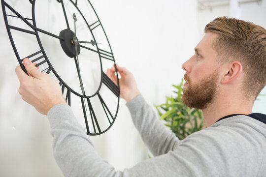 young man fixing the clock