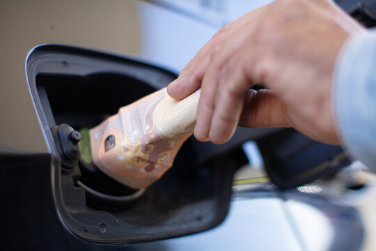 man pouring cash into his gas tank