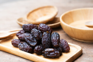 Dates in a wooden bowl are high-energy fruits that are eaten by Muslims during the fasting month of...