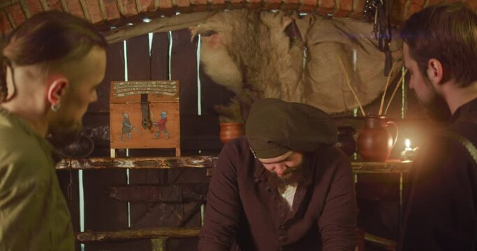 Merchant bargains with adventurers in tavern. Greedy obese seller makes profitable deal with pilgrims in medieval roadside pub. Fantasy characters interact