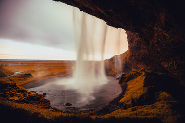 Beautiful view of Seljalandsfoss in Iceland on summer morning. View behind the water curtain of the...