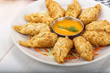 Fried stuffed momo dumplings with sauce