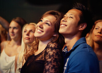 Music, night and crowd with couple at concert for band, happiness and festival date together. Fans,...