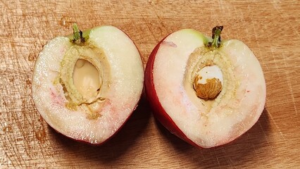 a cut peach on a cutting board