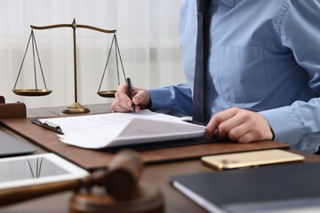 Lawyer working with documents at table indoors, closeup