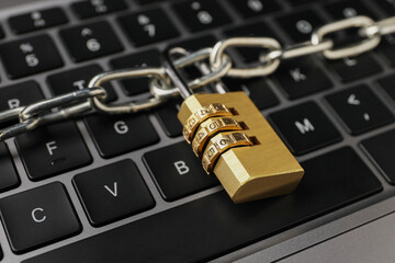 Cyber security. Padlock with chain on laptop, closeup