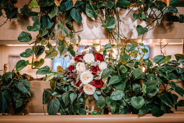 Riga, Latvia - January 20, 2024 - A vibrant wedding bouquet with red and white roses nestled among...