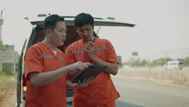 Rescue personnel preliminary talking by portable radio and working on tablet before being taken injured to the hospital. EMS Paramedic. First aid procedure. Emergency Medical First aid