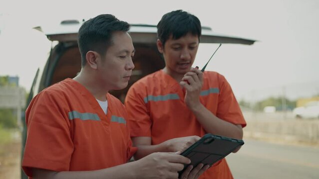 Rescue personnel preliminary talking by portable radio and working on tablet before being taken injured to the hospital. EMS Paramedic. First aid procedure. Emergency Medical First aid