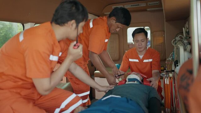 Team paramedic in uniform helping crash victim after car accident, loading patient on stretcher into an ambulance. EMS Paramedic. First aid procedure. Emergency Medical First aid