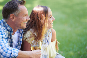 Couple, picnic and wine glasses for bonding in outdoor nature, love and romance in relationship on weekend. Alcohol, conversation and people in countryside, adventure and grass or happy on vacation